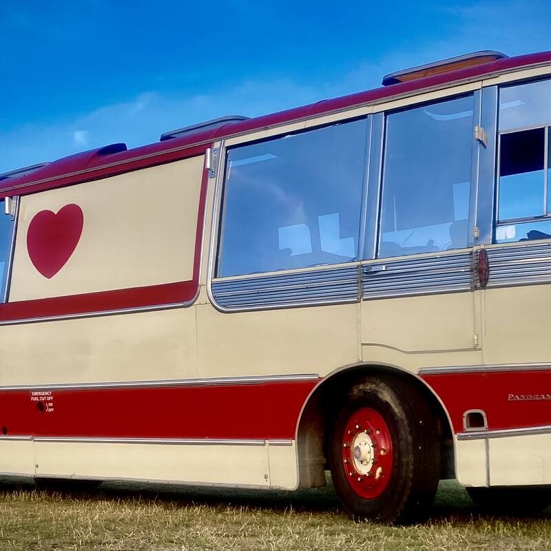 The heart motif on the side of The Love Bus against a blue sky