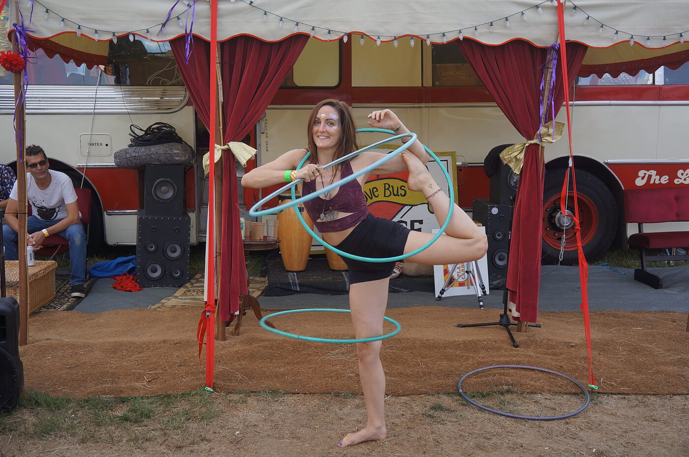 A hoop performer in front of The Love Bus