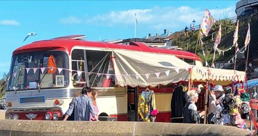 The Love Bus with its canopy and bunting on a seaside promenade