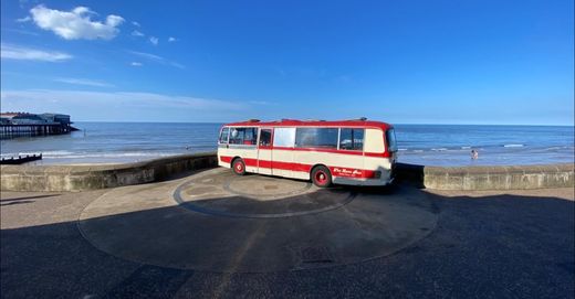 The Love Bus on the promenade overlooking the sea and the pier