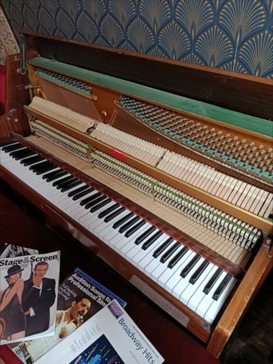 The Love Bus piano with its lid open showing the keys and hammers