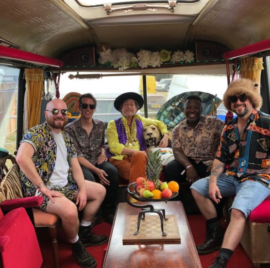 A band relaxing on the sofas inside The Love Bus at Maui Waui 2025