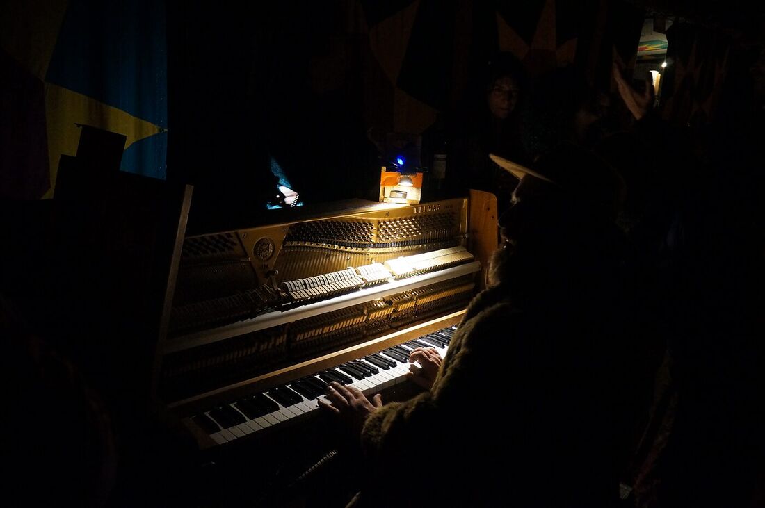 The resident piano lit up inside The Love Bus at night